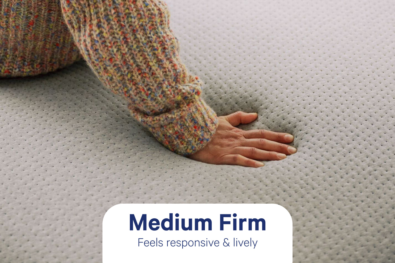 A hand pressing into a memory foam mattress surface.
