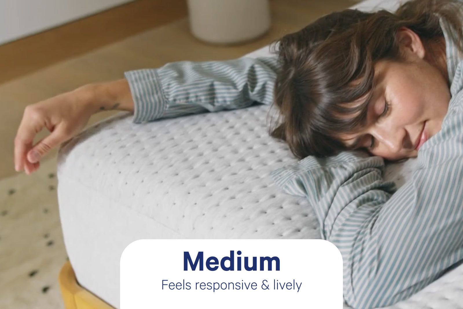 A hand pressing into a hybrid mattress surface.
