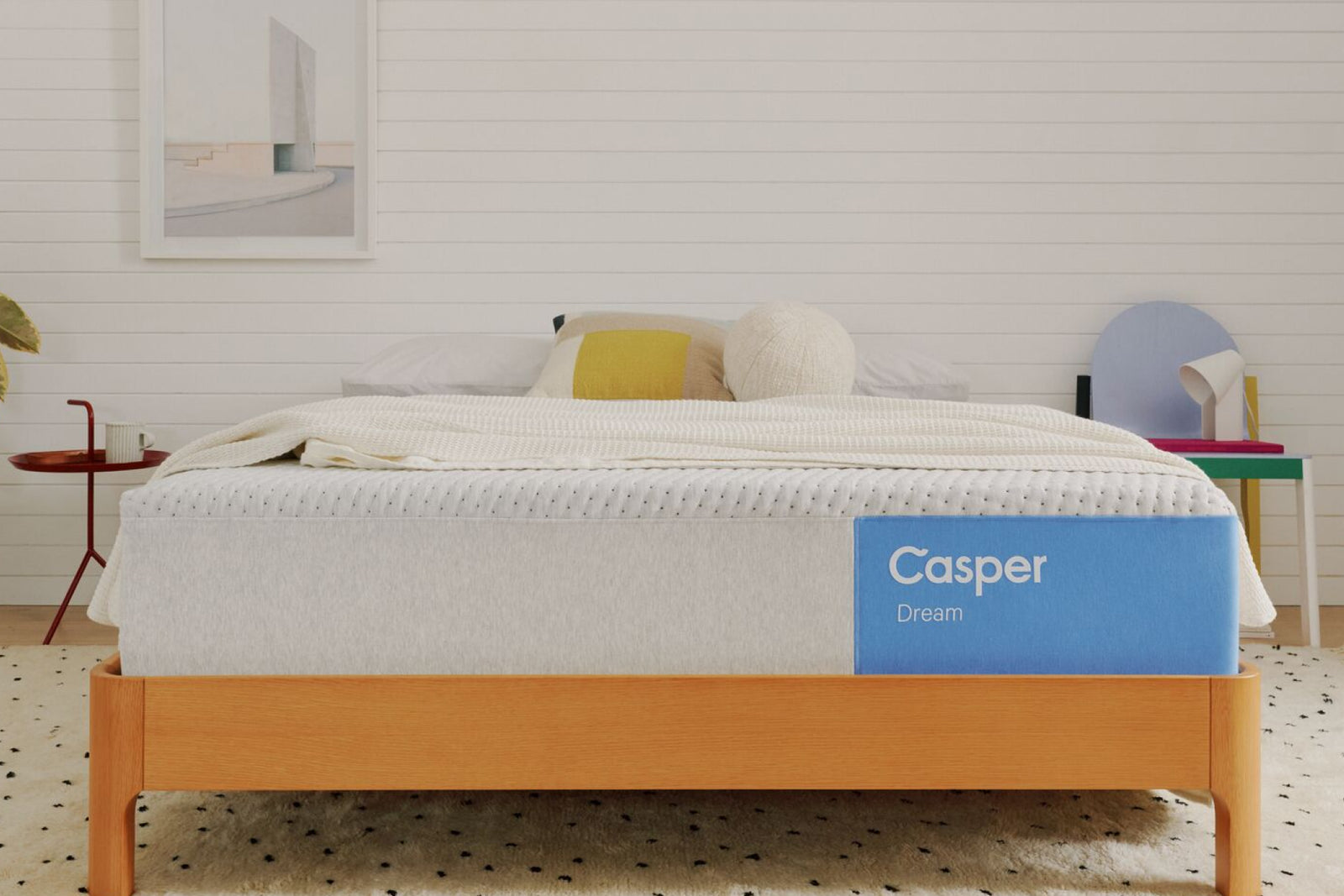 A mattress on a wooden bed frame in a bedroom.
