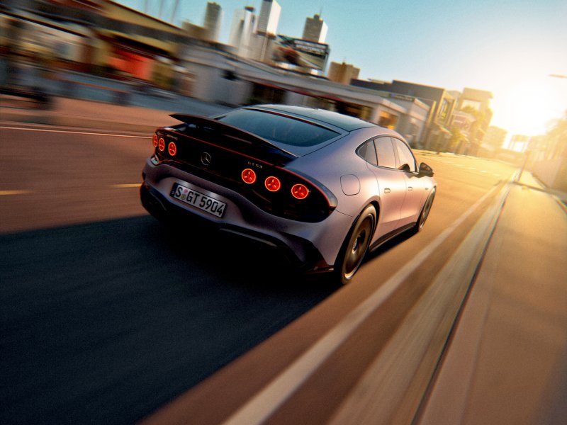 2026 Mercedes-AMG GT 63 4-Door Coupe driving through a city at sunset.
