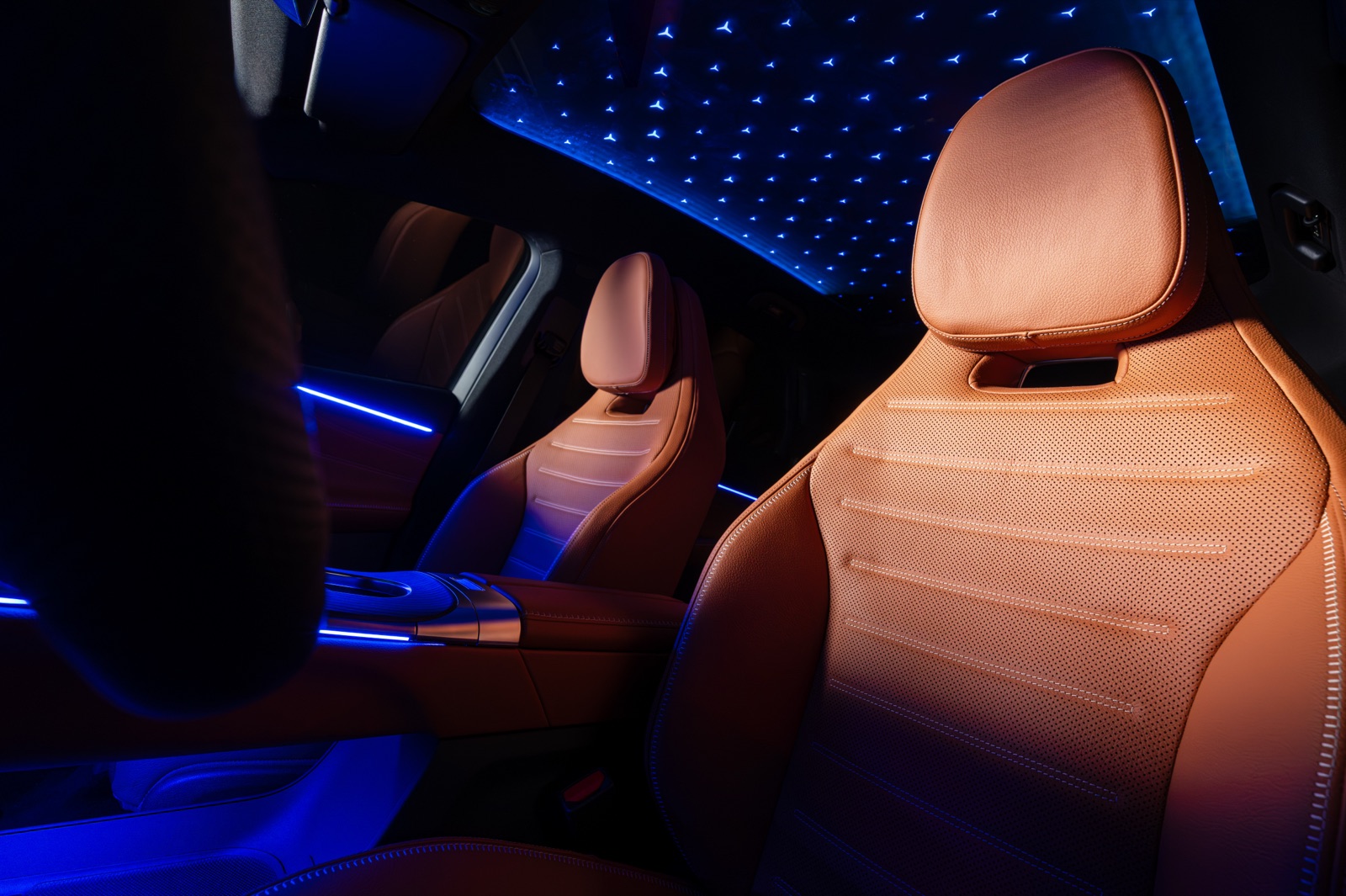 GLC front seats in tan leather at night, with the star-pattern ambient lighting lit across the headliner.