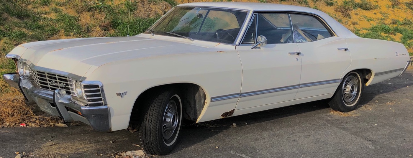 A 1967 Chevrolet Impala, white, real photograph.
