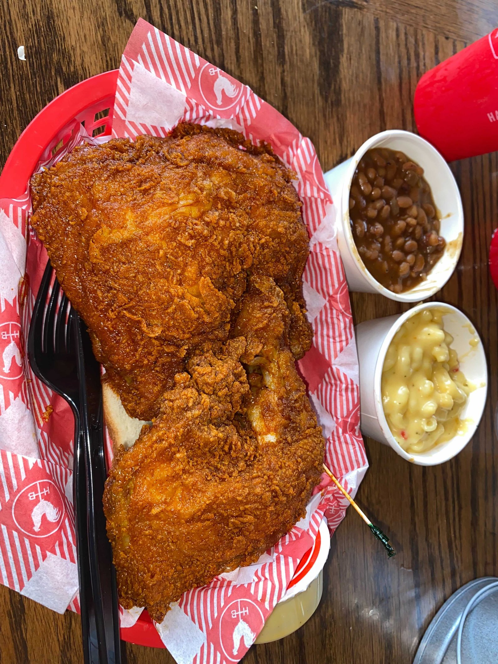 Half-chicken dark meat plate at Hattie B's with baked beans and mac and cheese, a real photograph.