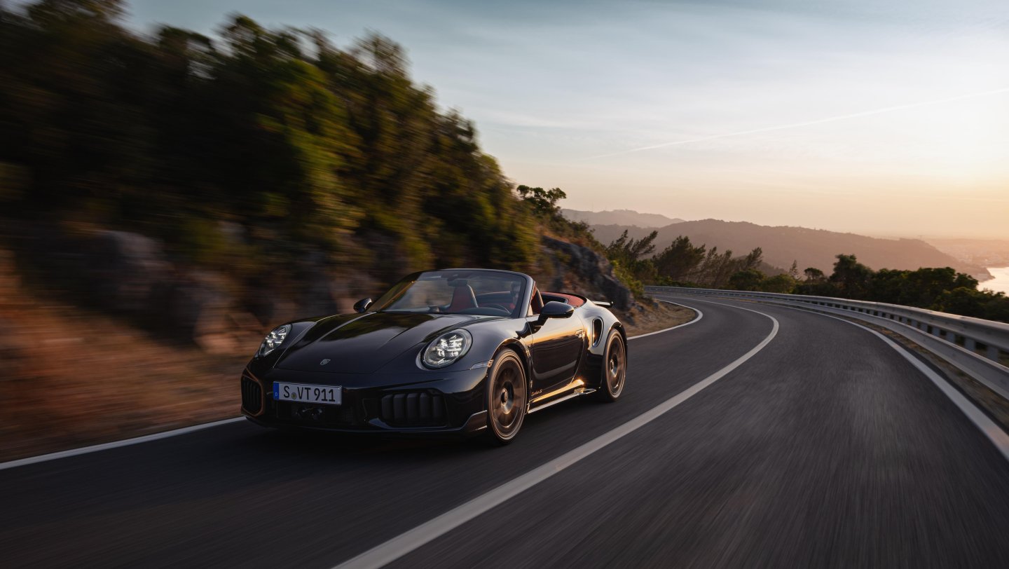 911 Turbo S Cabriolet driving on a coastal mountain road.