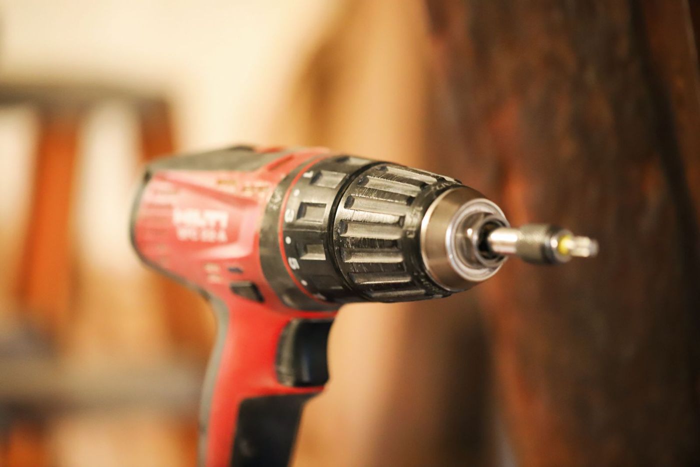 Close-up of a red cordless drill with a bit in the chuck