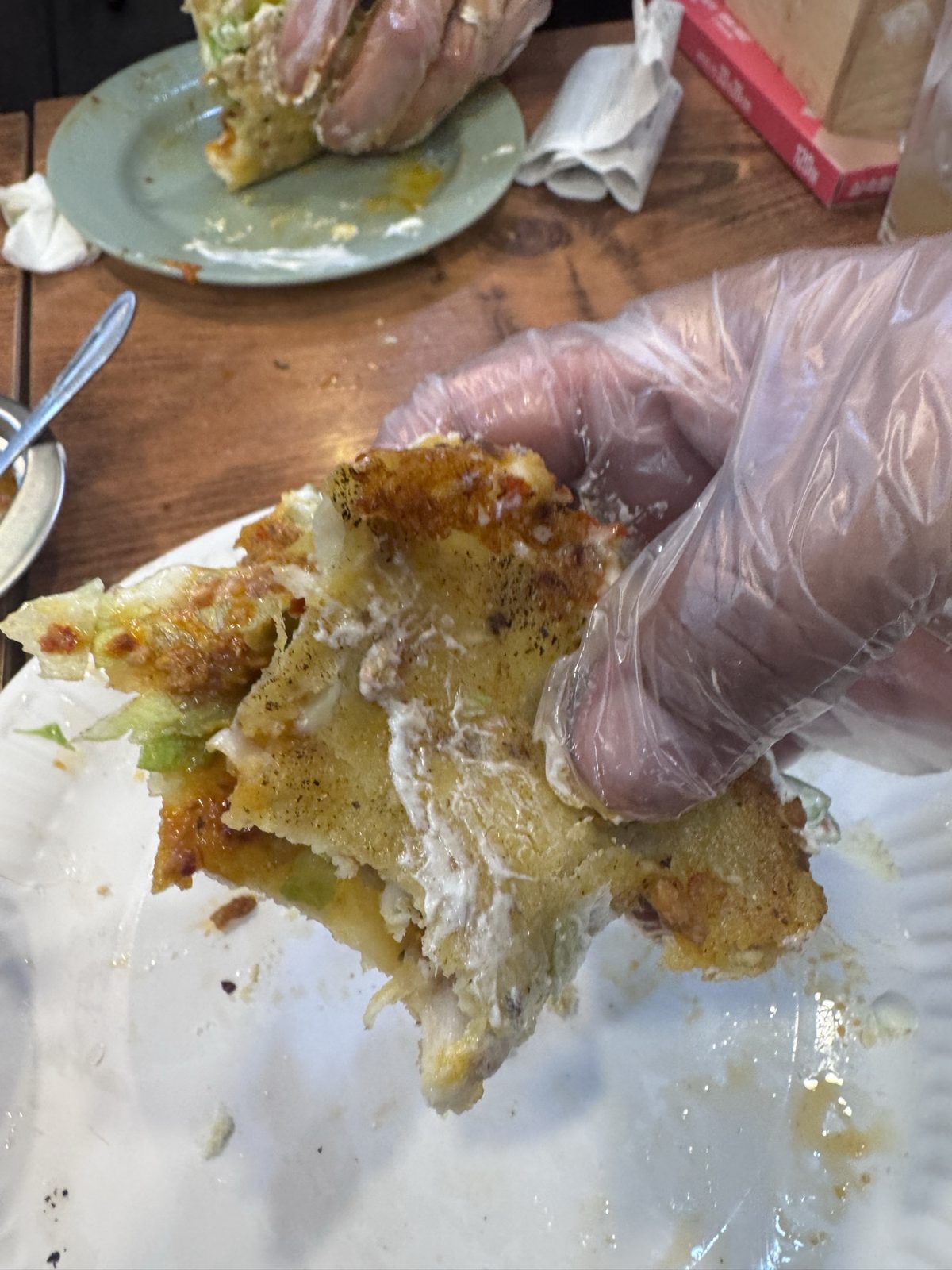 A potato-and-chorizo quesadilla at Taco La Mexicana, torn open by a gloved hand.