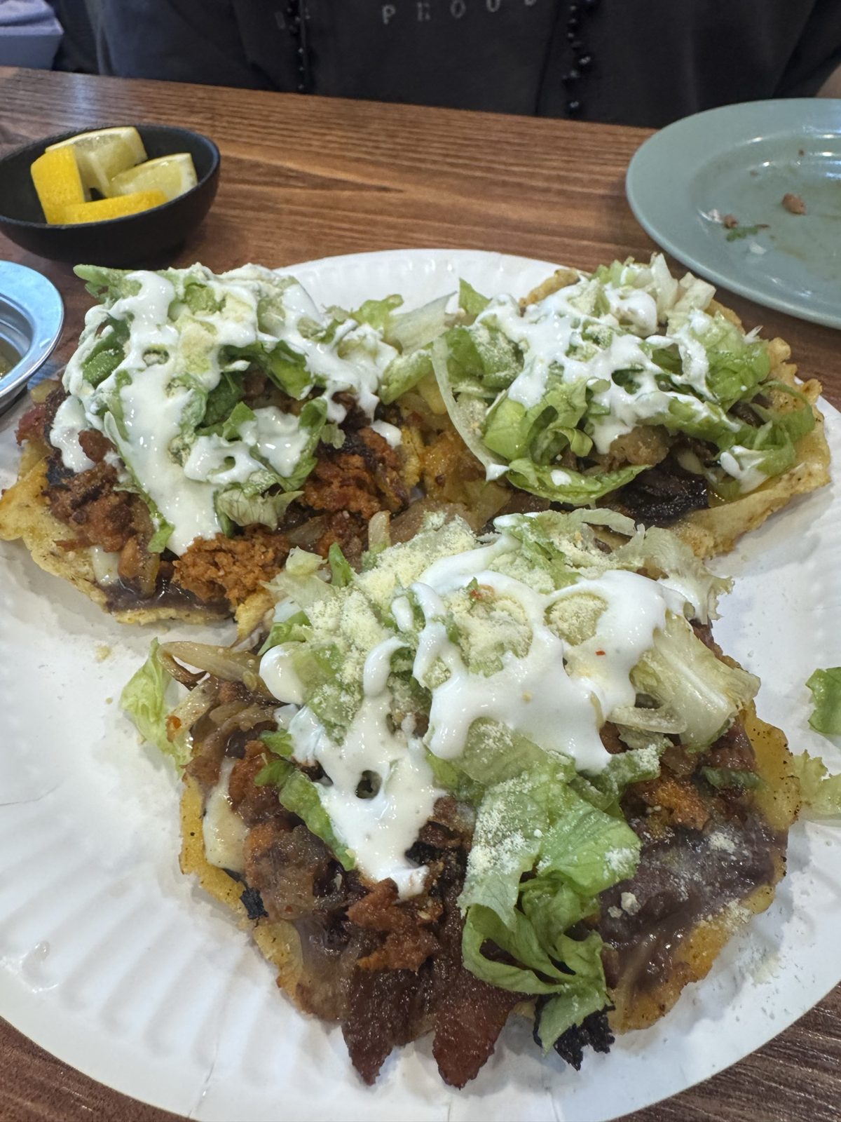 Three sopes at Taco La Mexicana topped with meat, lettuce, crema and cheese.