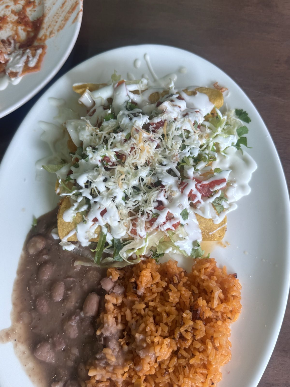 Flautas at Taco Amigo topped with lettuce, crema and cheese, with rice and beans.