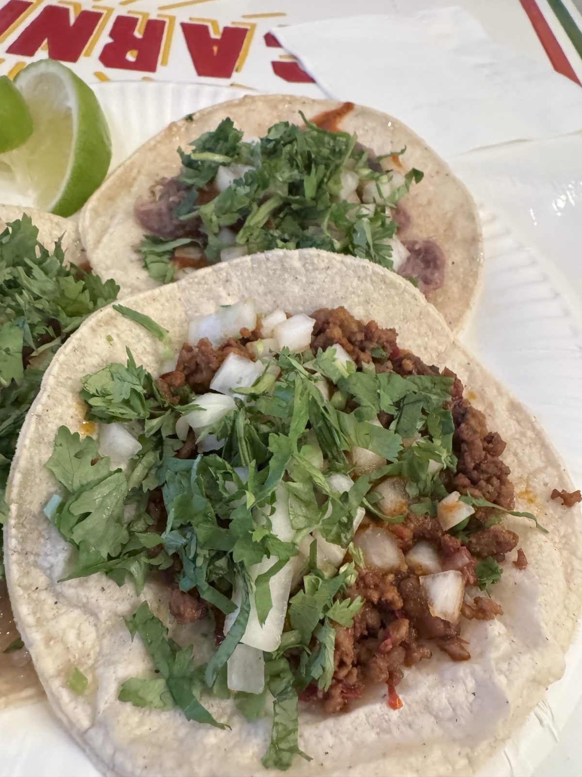 Close-up of Villa Guerrero tacos with onion and cilantro over the meat.