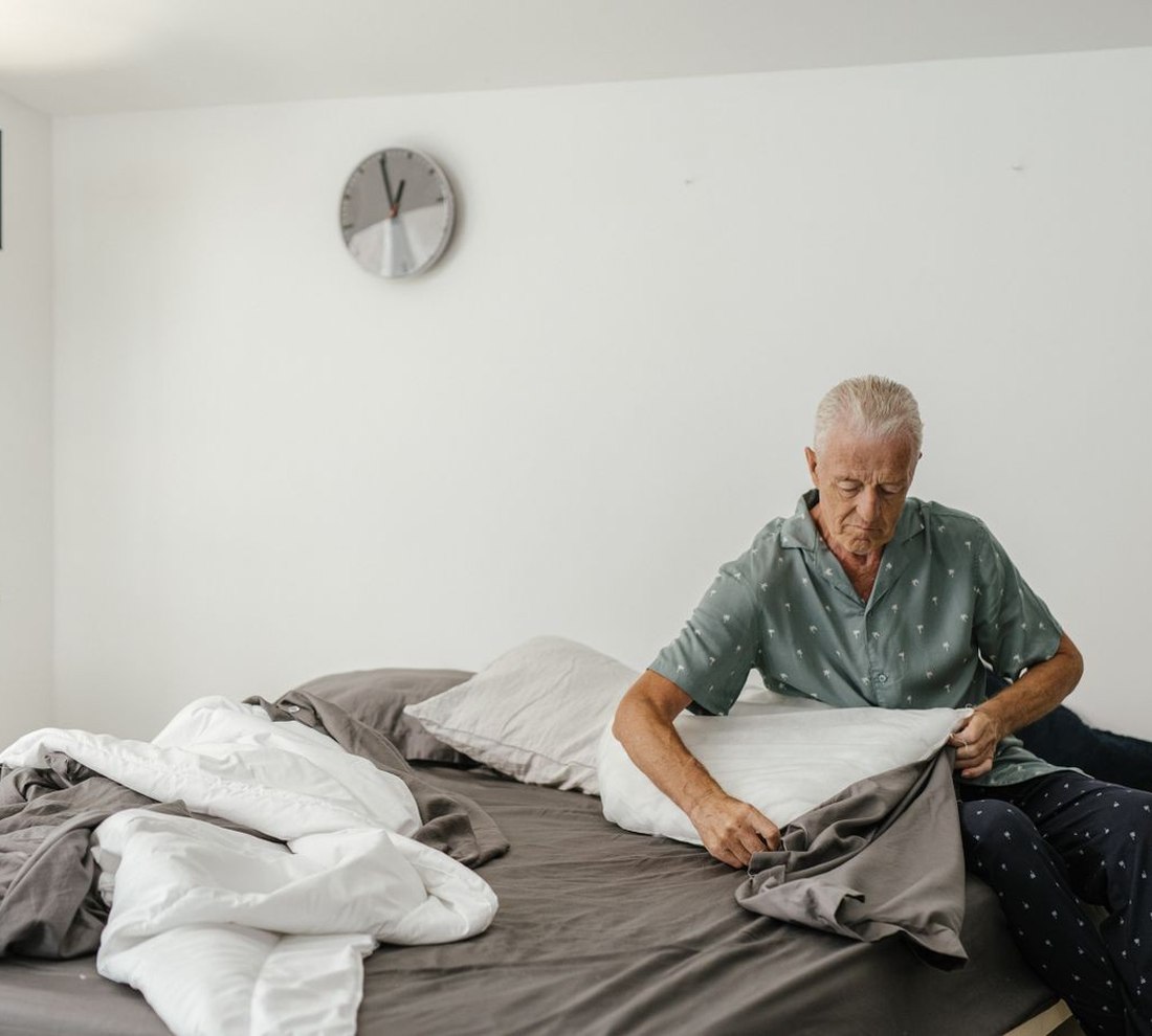 A man making up a bed at home, setting the room up before an operation