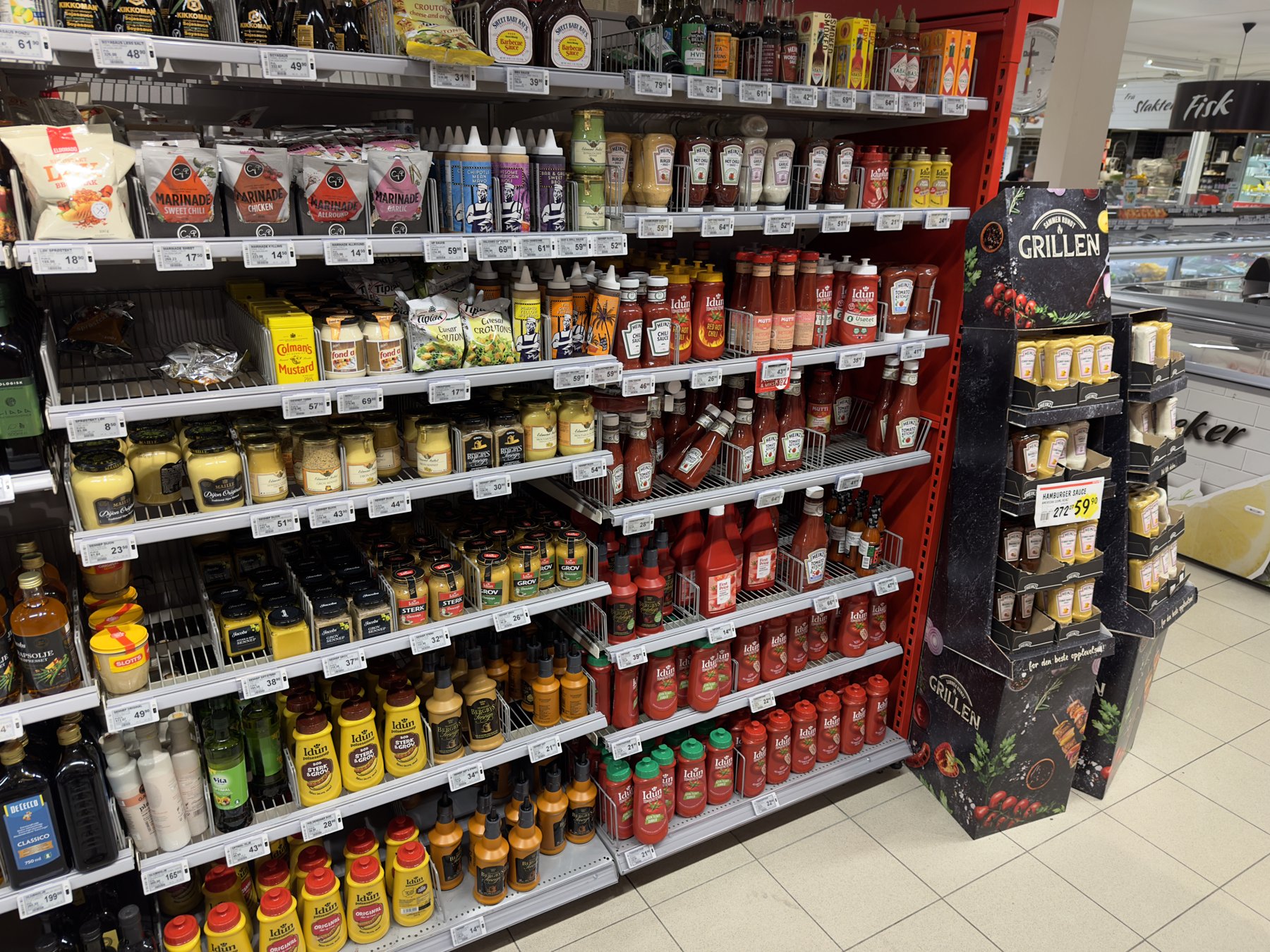 A real grocery store aisle stocked with condiment brands including Heinz