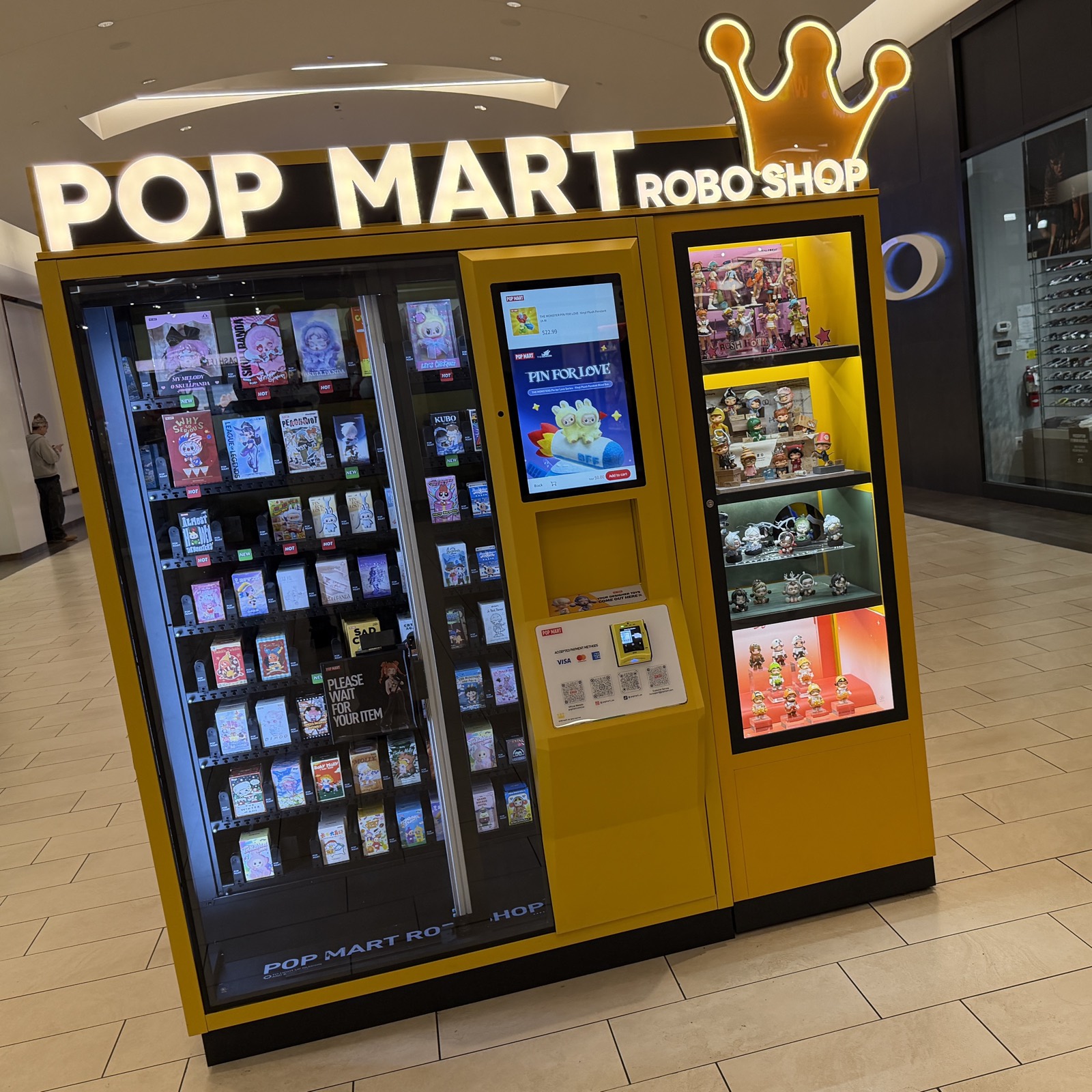 A Pop Mart 'RoboShop' vending kiosk stocked with blind boxes and display figures, real photograph.