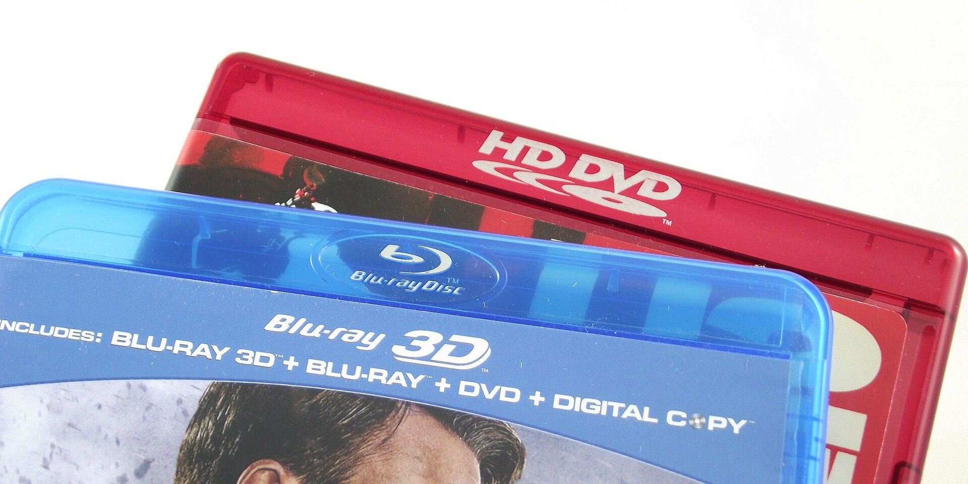 Close-up of stacked Blu-ray and HD DVD disc cases showing their format logos, real photograph.