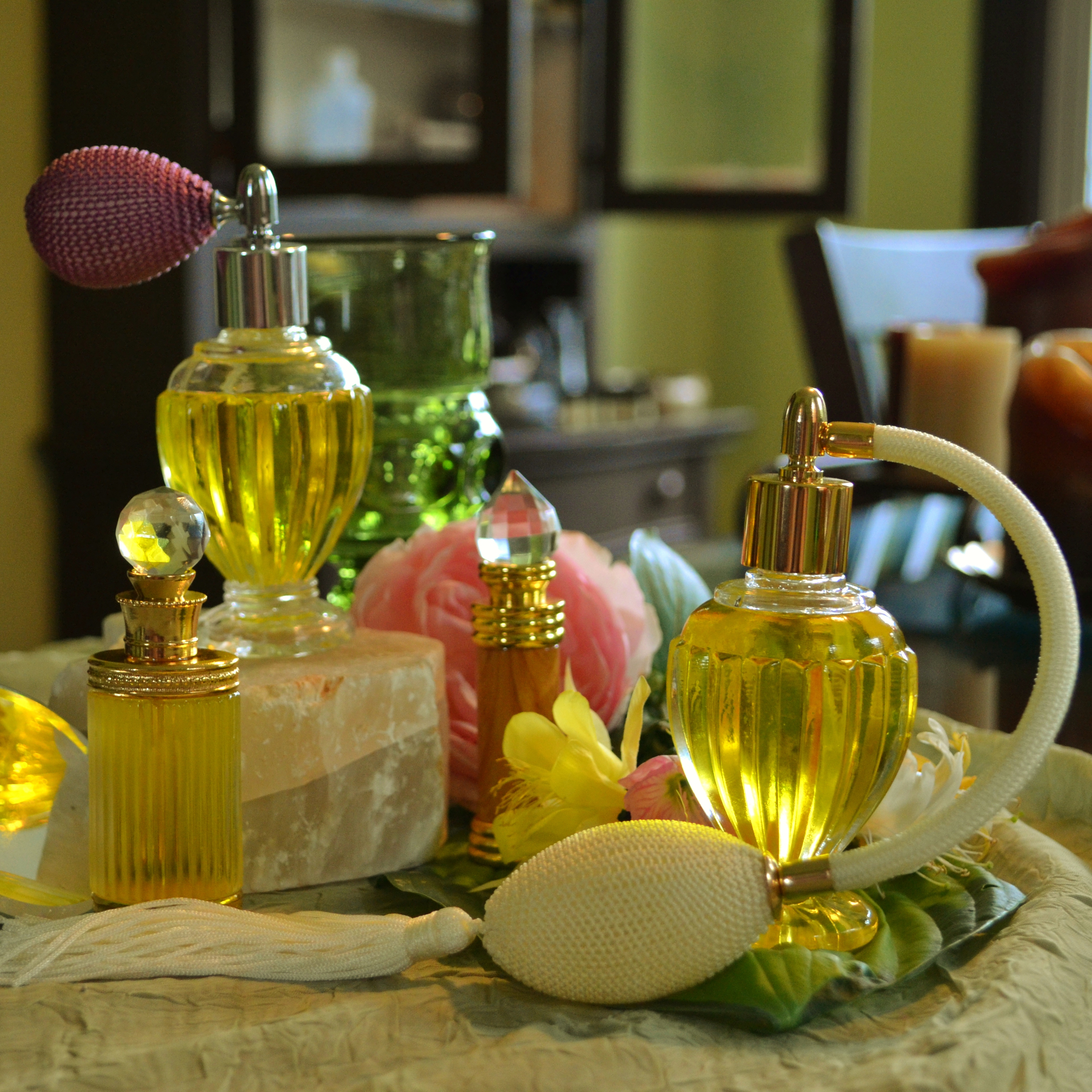 A cluster of ornate glass perfume bottles with atomizer bulbs and gold fittings, a real photograph.