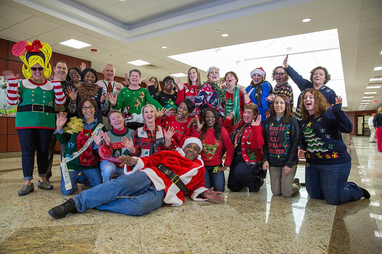 City of North Charleston employees wearing ugly Christmas sweaters at an office Ugly Christmas Sweater Day event, real photograph.