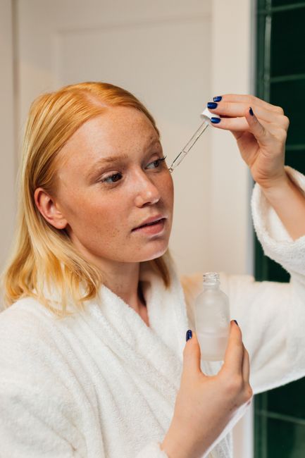applying skincare serum to face
