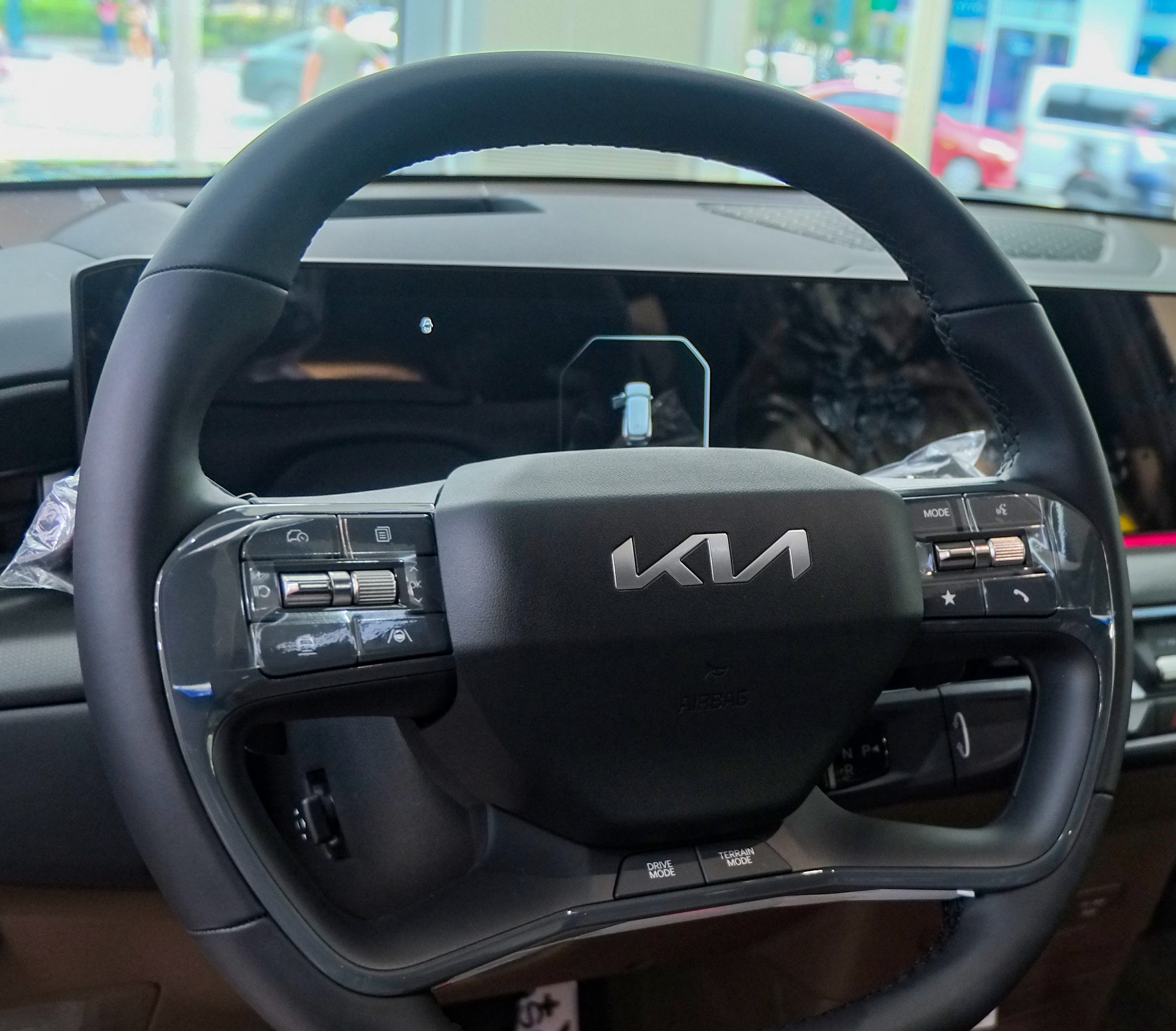 Kia EV9 steering wheel closeup with haptic buttons.