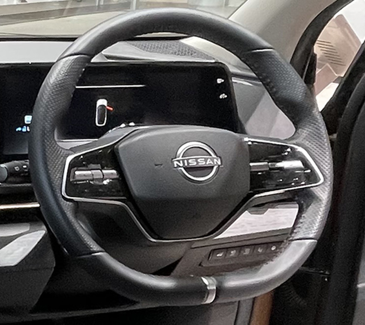 Nissan Ariya steering wheel closeup showing haptic touch controls.