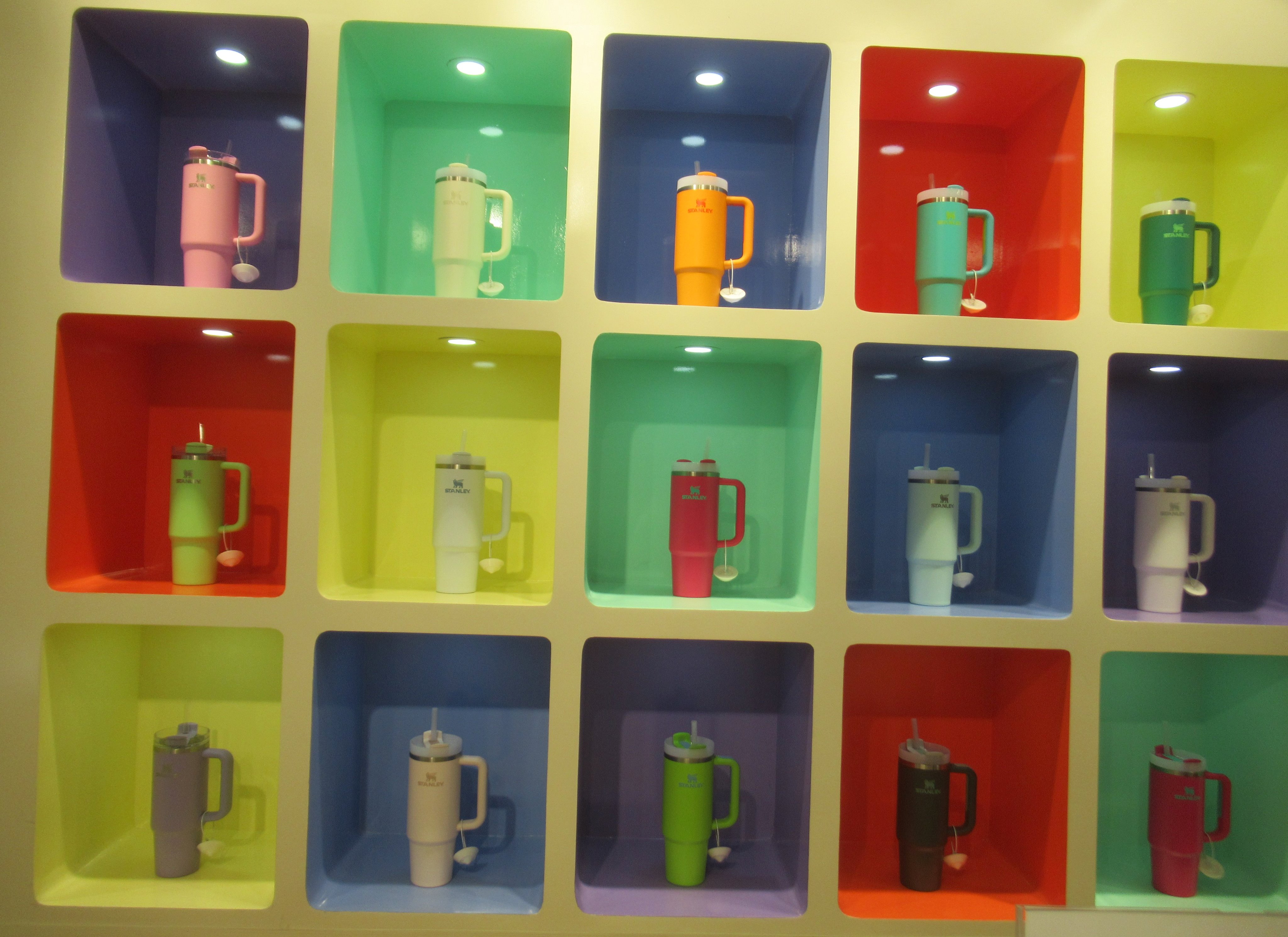 A retail display of Stanley bottles, tumblers, and vacuum flasks at a shopping mall, real photograph.