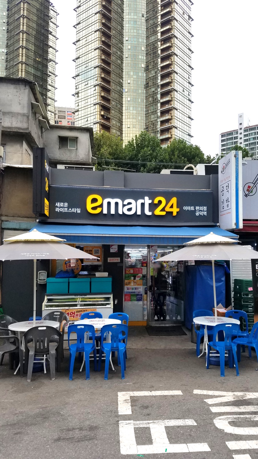 An Emart24 convenience store storefront at night in South Korea.
