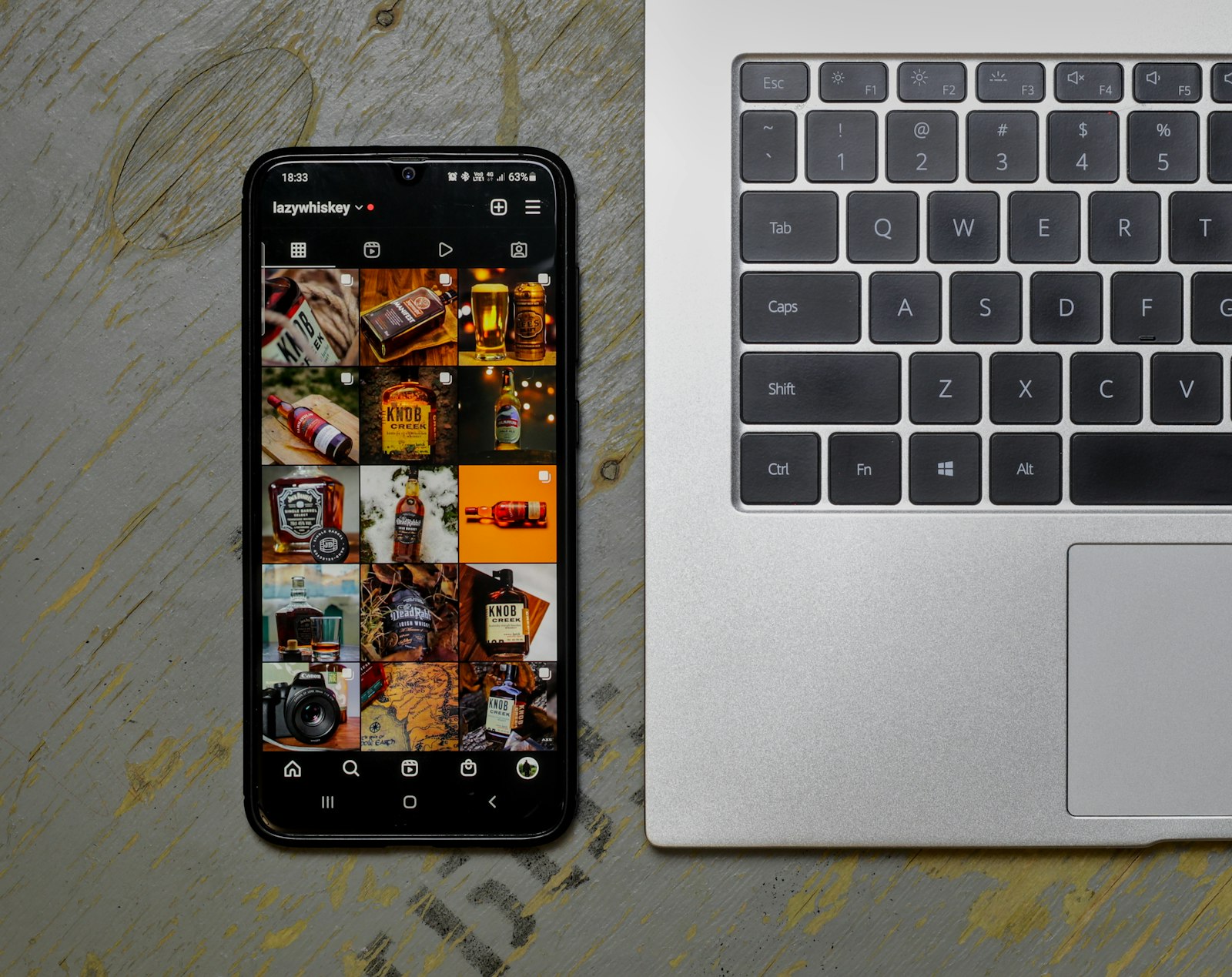 An open laptop computer sitting next to a cell phone